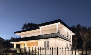 Tetto metallico moderno: tegole effetto coppo e Alluminio prefalz P10 aggraffata verticale Antracite. Rifacimento copertura in metallo Rutaroof. Design ibrido con doppia finitura Grigia.